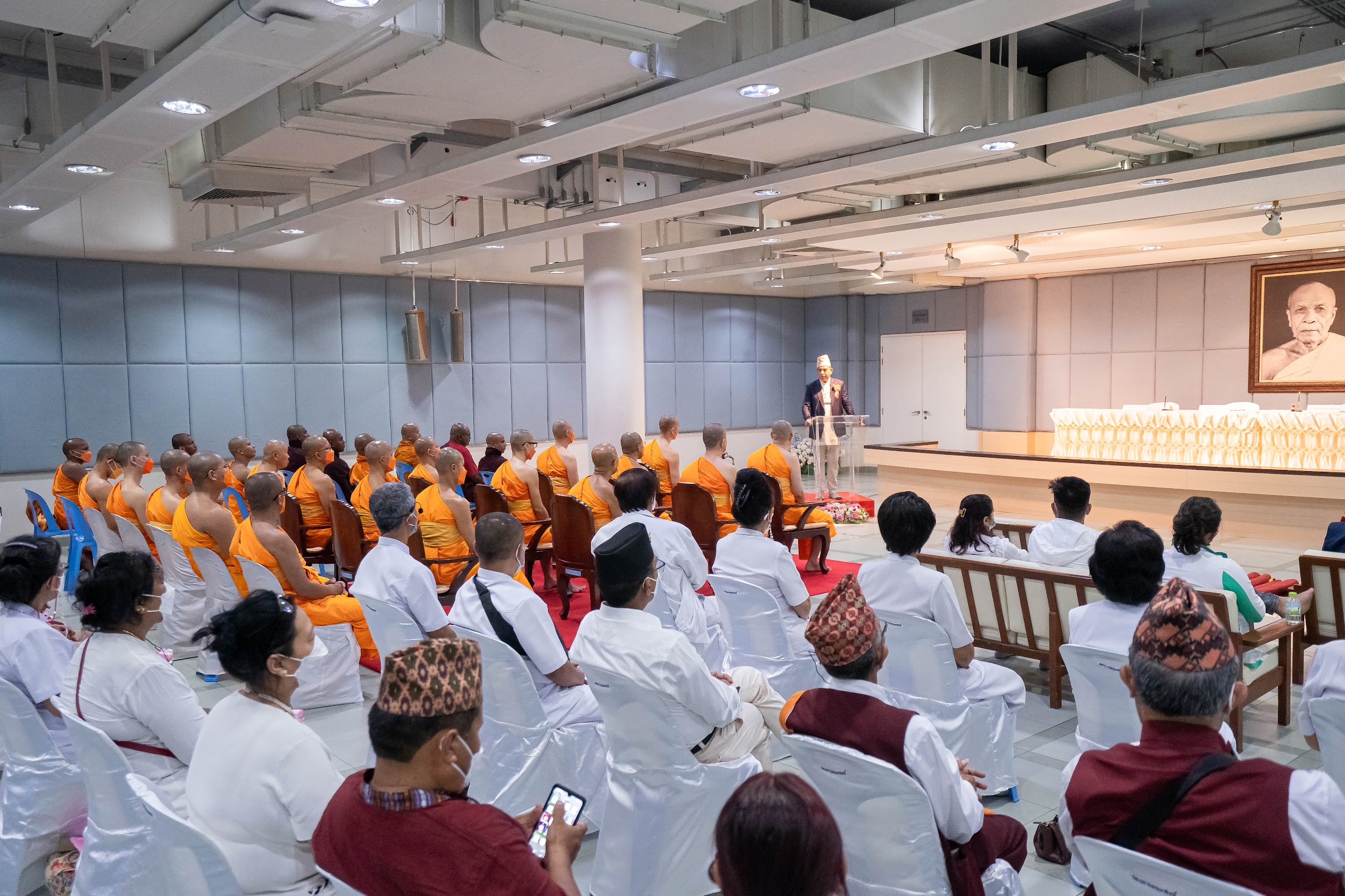 Buddhist monks and lay devotees attending dhamma discourse ceremony at Buddhist hall